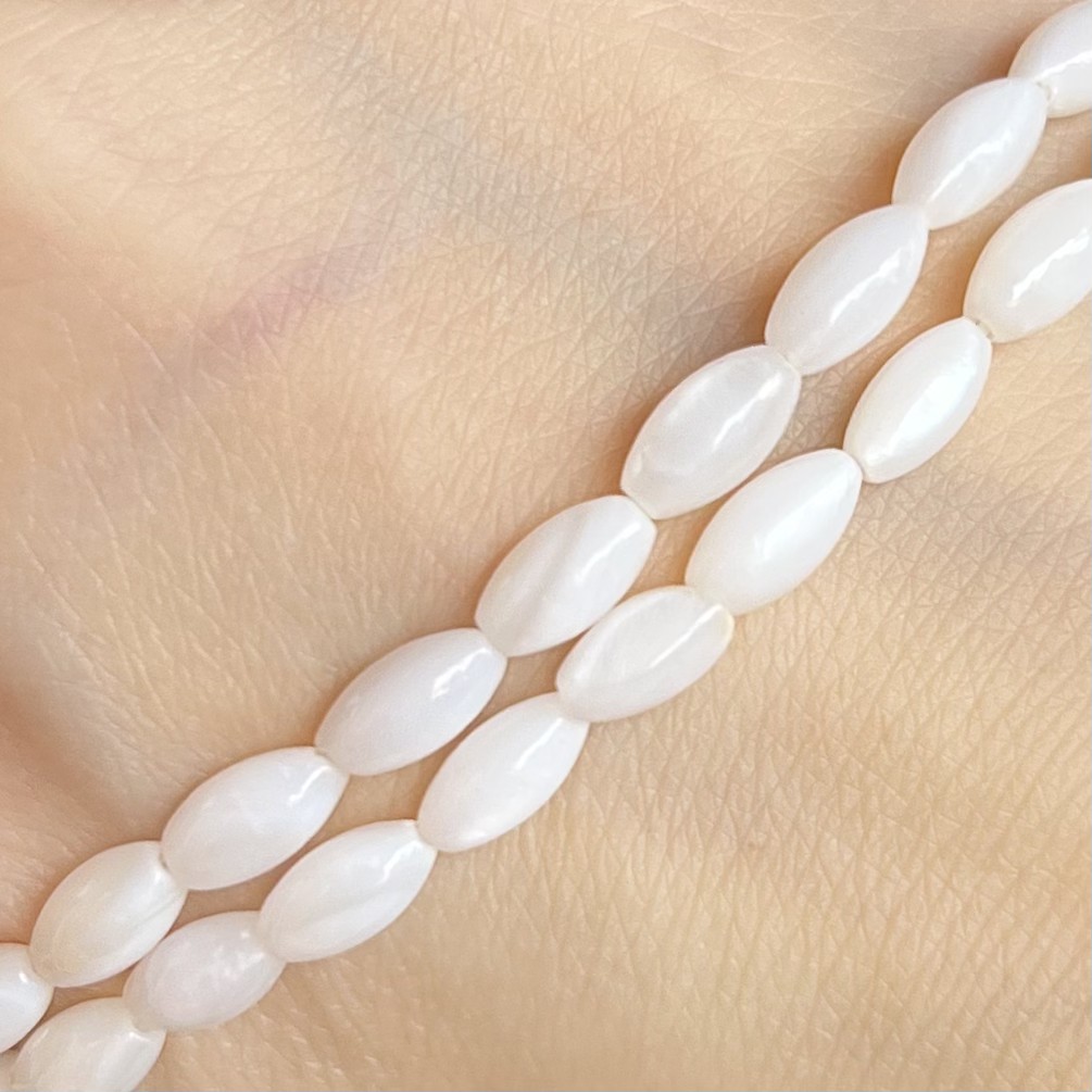 Oválky z mušloviny, 8x4 mm, půlšňůra 19 cm (cca 25 korálků)